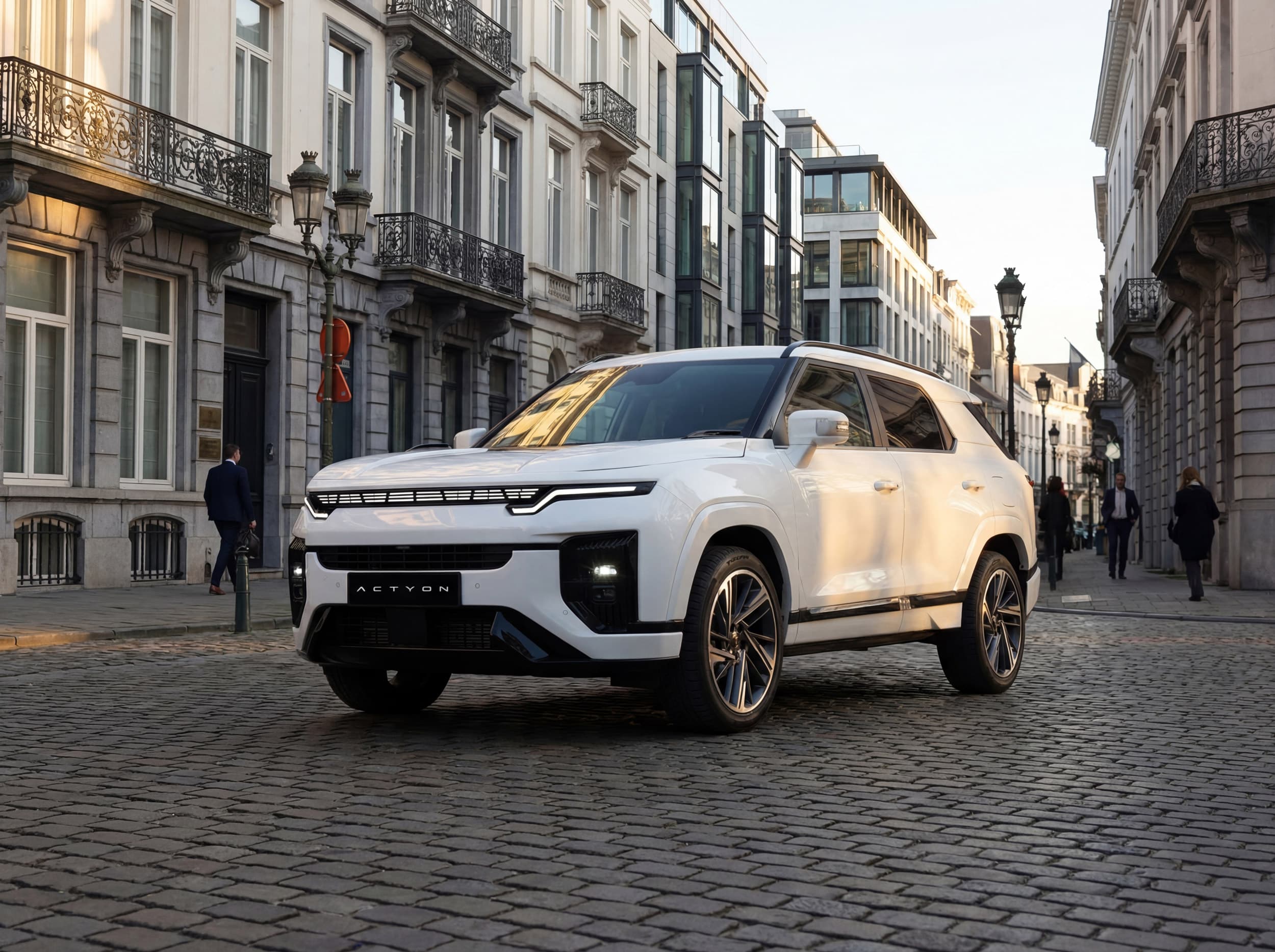 White Actyon parked on a cobblestone street, surrounded by historic European architecture and a few pedestrians.