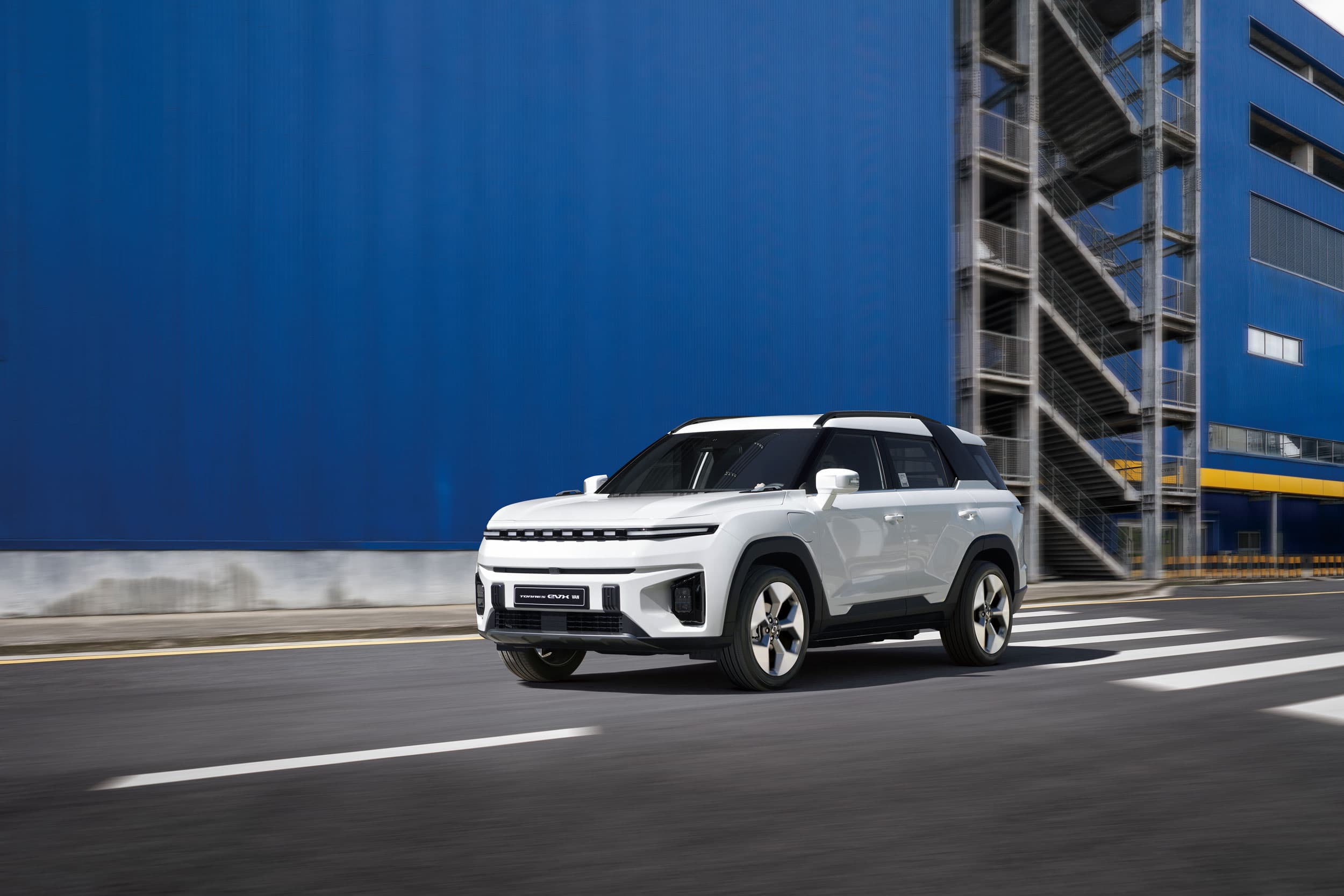 KGM Torres EVX VAN driving by warehouse